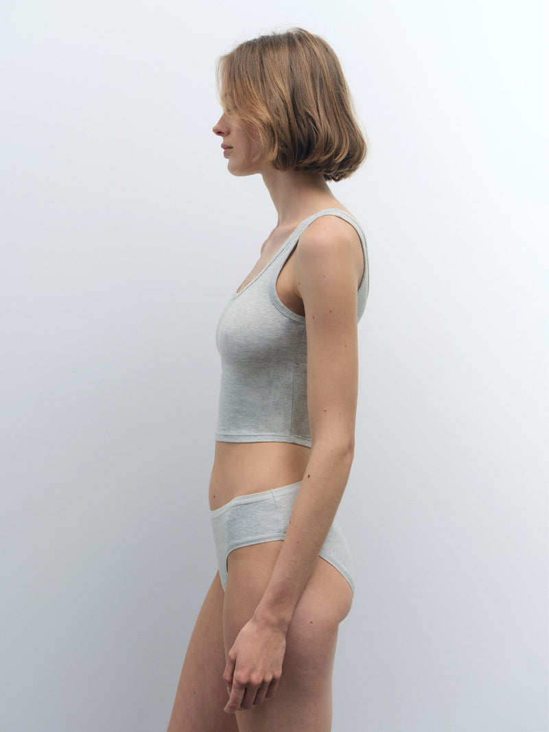 Woman in profile wearing a light gray organic cotton crop tank and matching briefs.