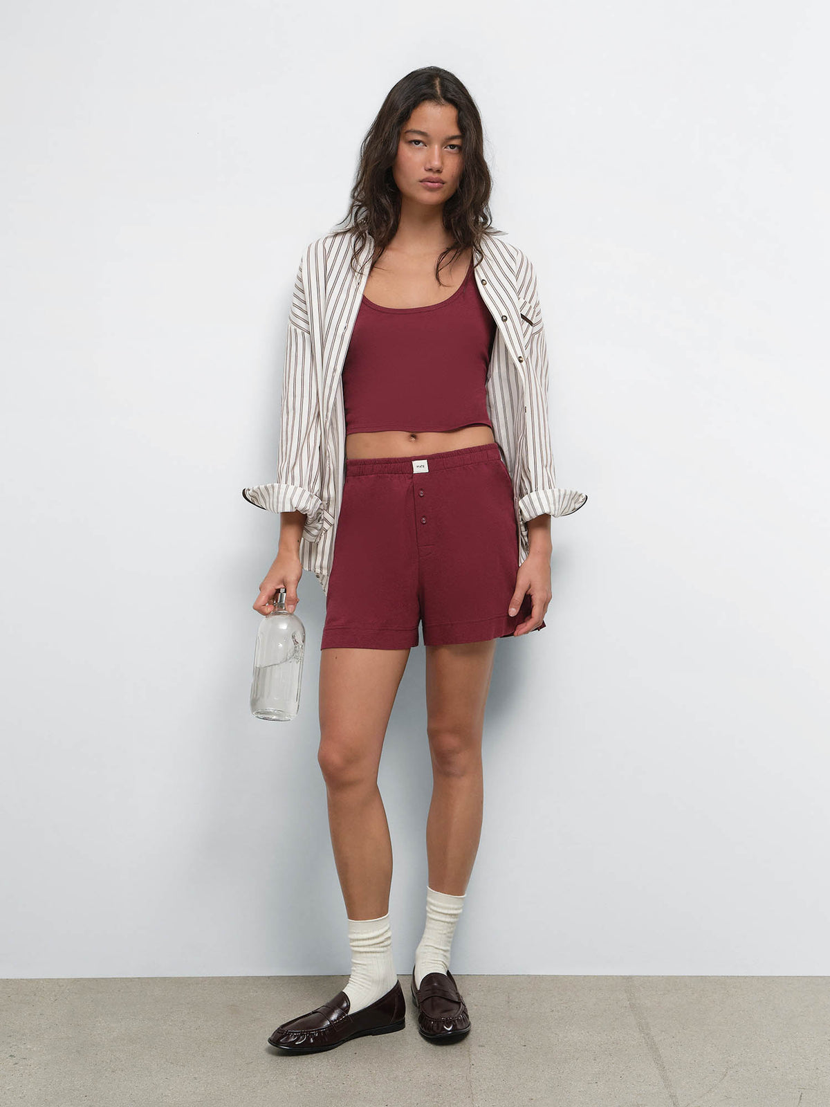 Full-length view of model in a striped shirt over the Tencel Sleep Scoop Tank in Garnet and matching shorts with white socks and loafers