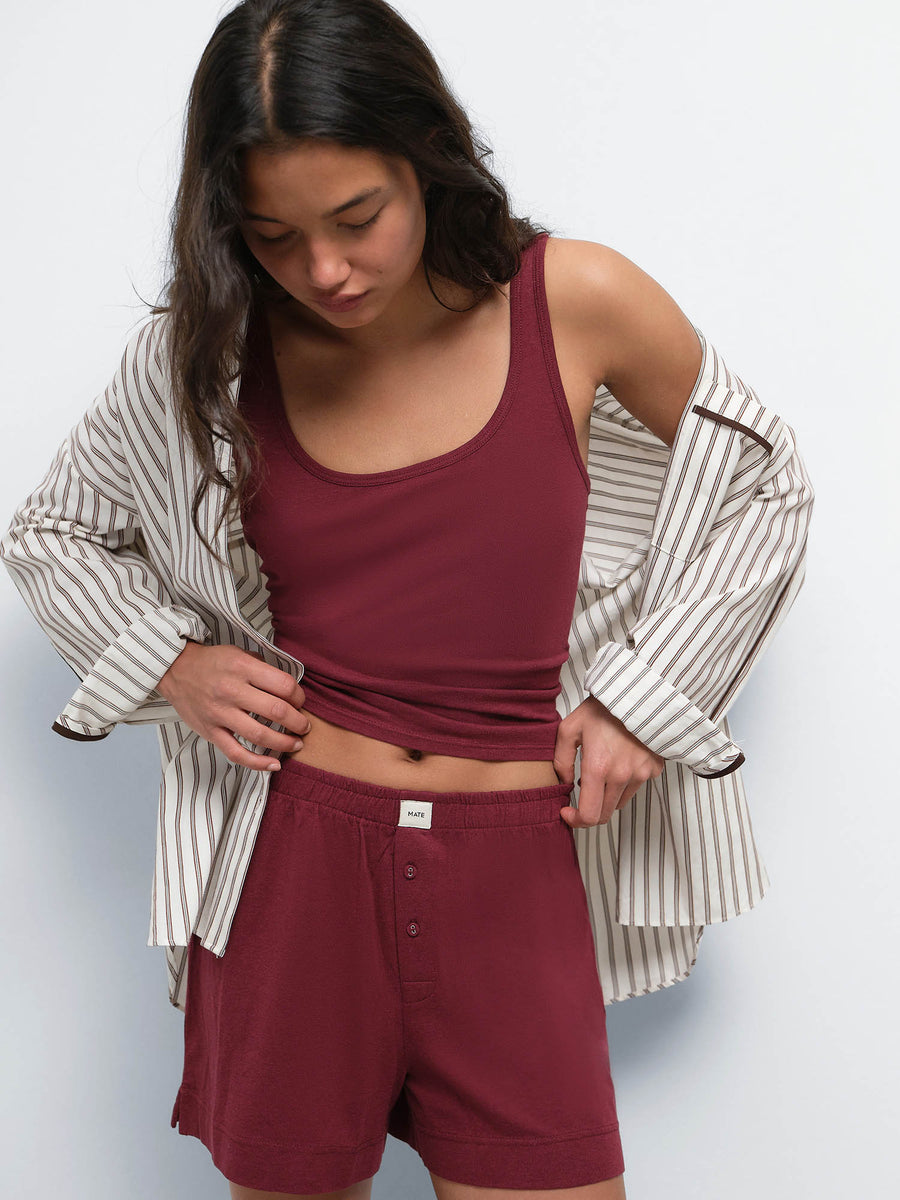 Model with a striped shirt off her shoulders over the Tencel Sleep Scoop Tank in Garnet and matching shorts