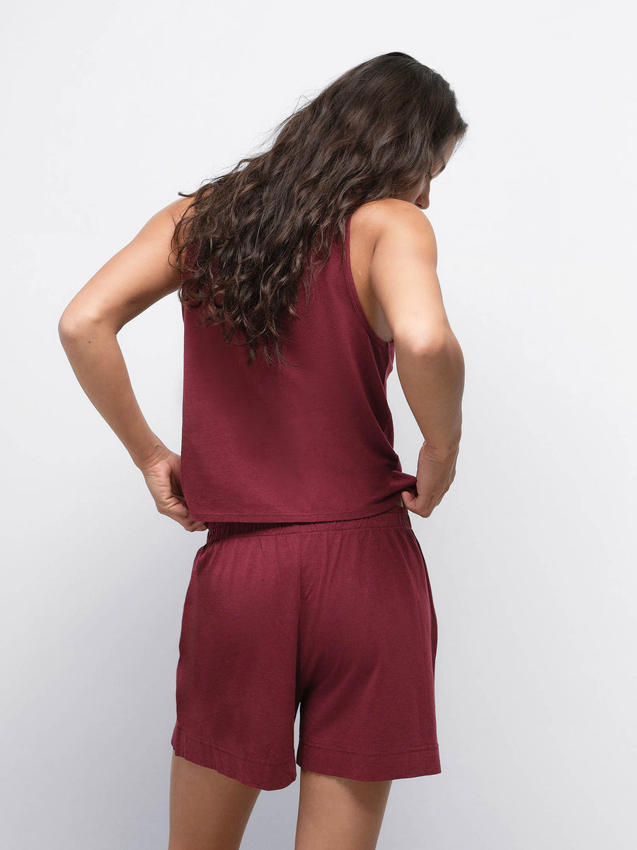 Back view of model wearing the Tencel Sleep Scoop Tank in Garnet with matching shorts