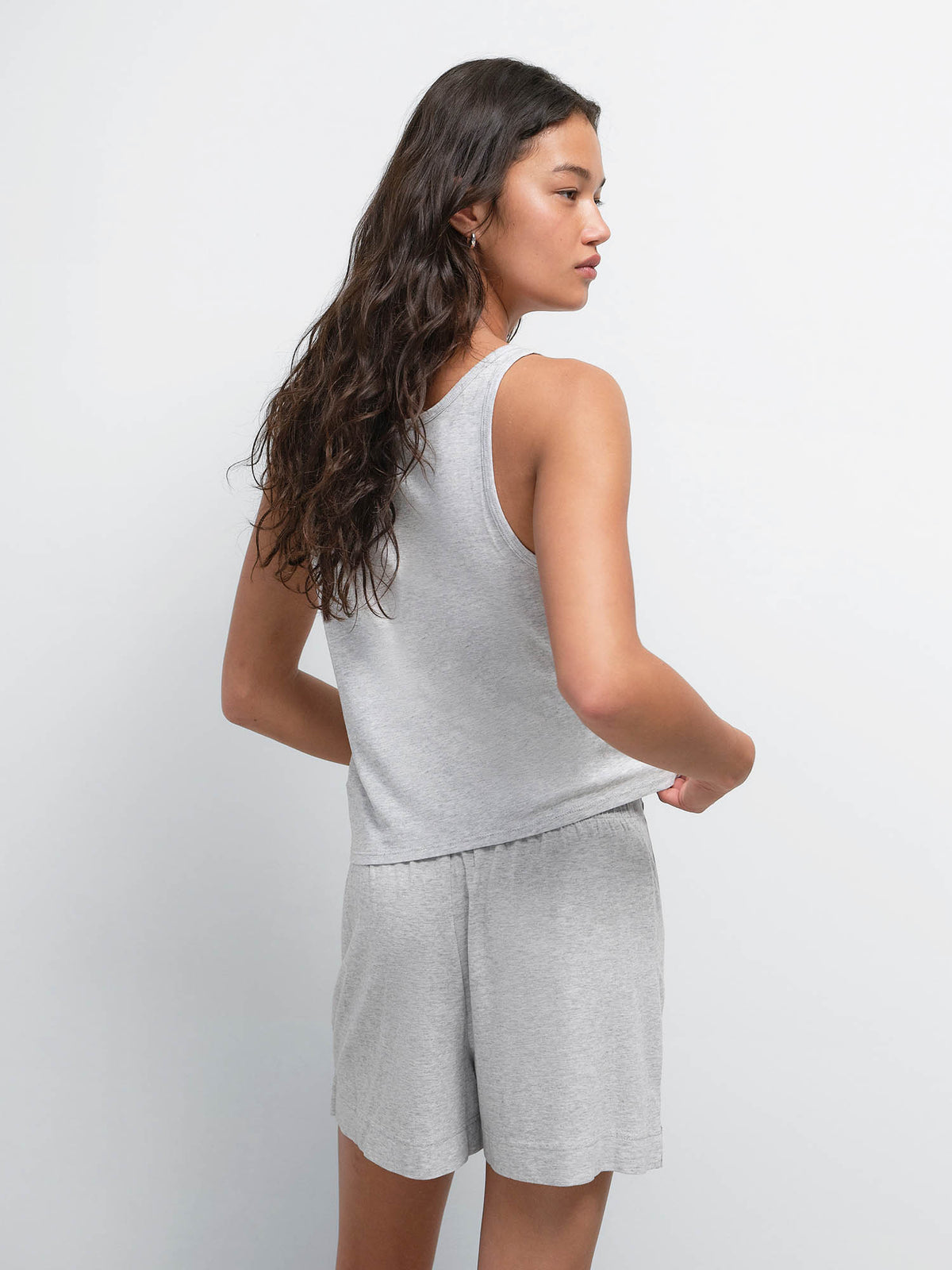 Back view of model looking over her shoulder in the Tencel Sleep Scoop Tank and Boxer Short in Heather Grey