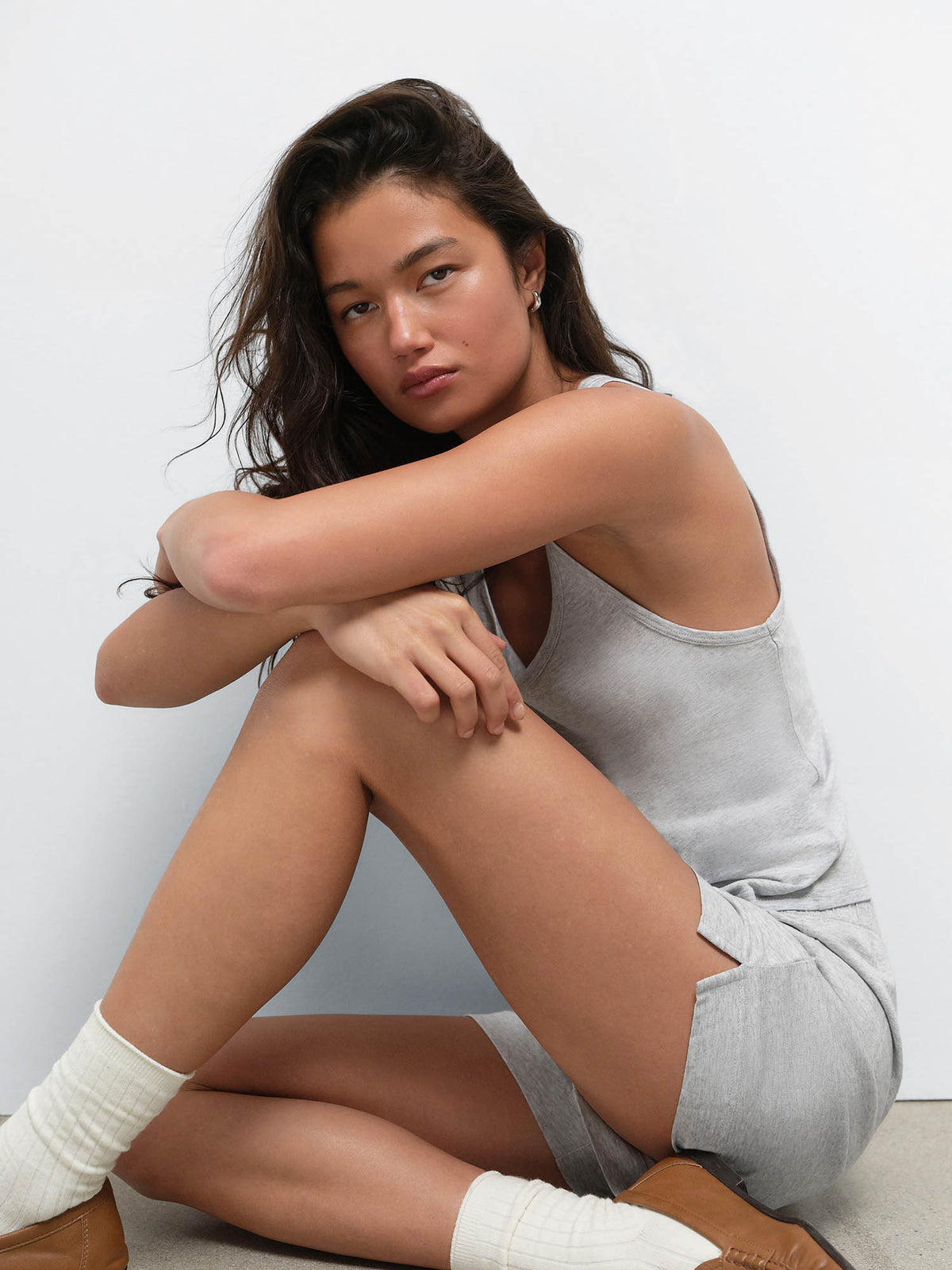 Seated model resting her arms on her knee in the Tencel Sleep Scoop Tank and Boxer Short in Heather Grey