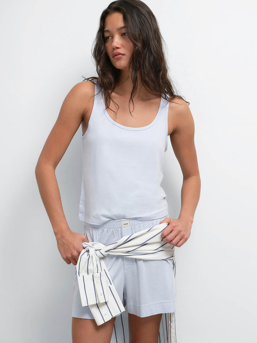 Model with hands on hips in the Tencel Sleep Scoop Tank and Boxer Short in Powder, striped shirt tied at the waist