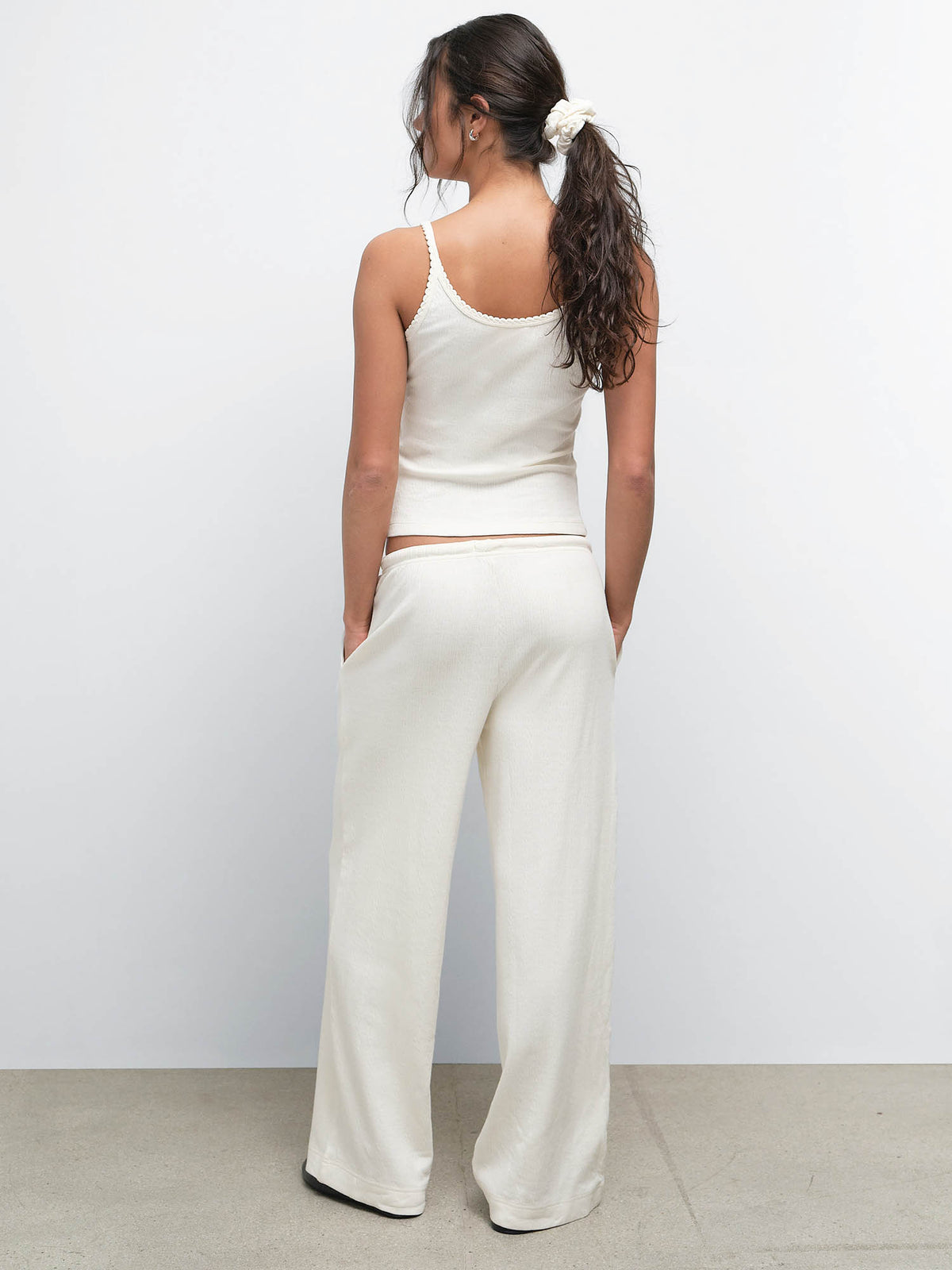 Back view of model with a ponytail wearing the Organic Pointelle Tank and Pant in Cream