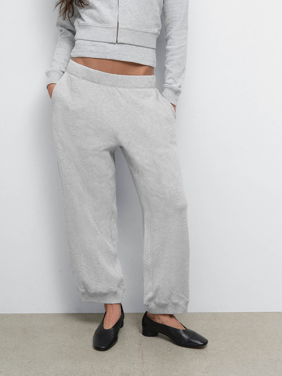 Close-up of model with hands in pockets wearing the Organic Pointelle Jogger in Heather Grey with black loafers