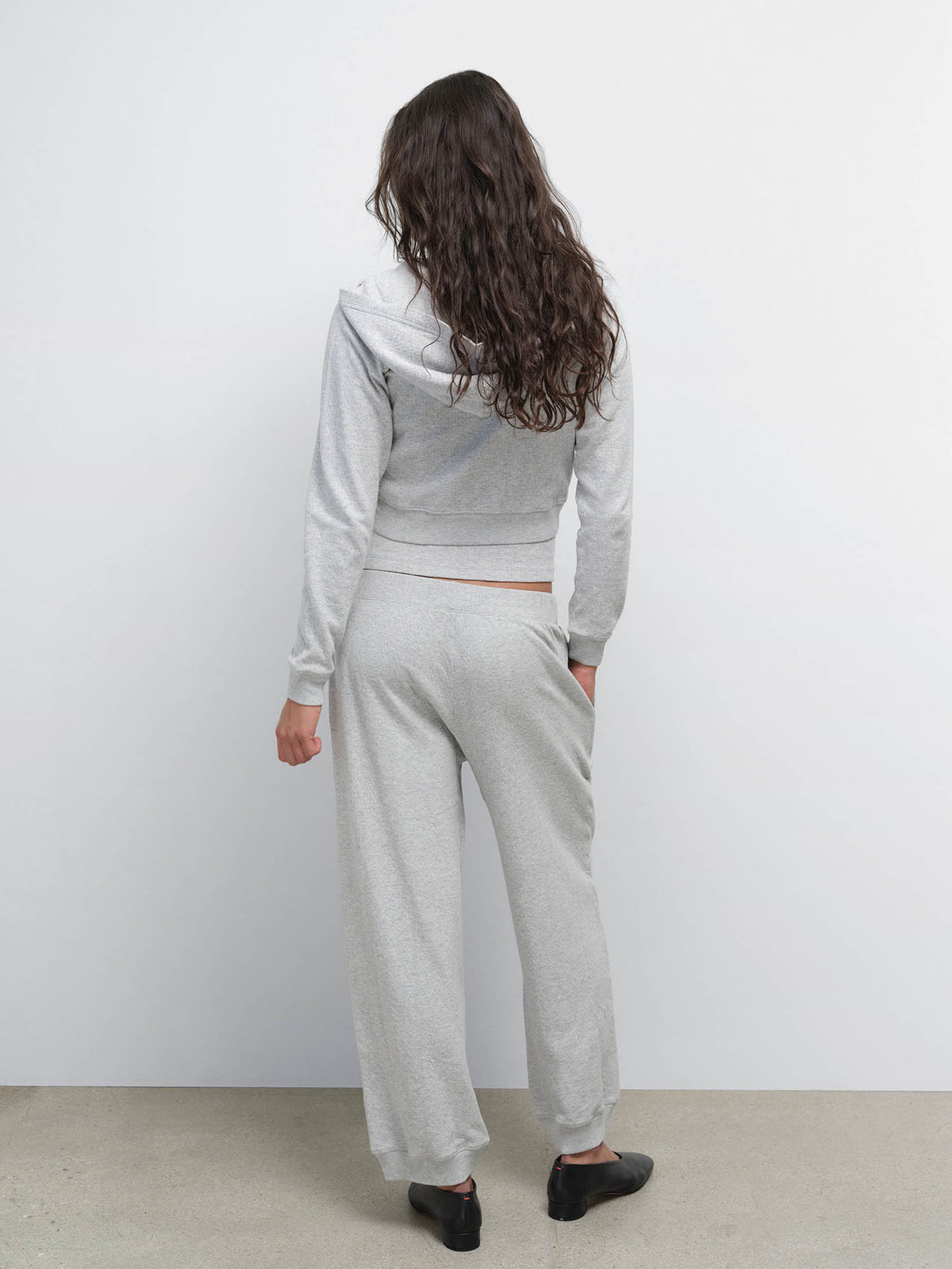 Back view of model in the Organic Pointelle Shrunken Hoodie and Jogger in Heather Grey