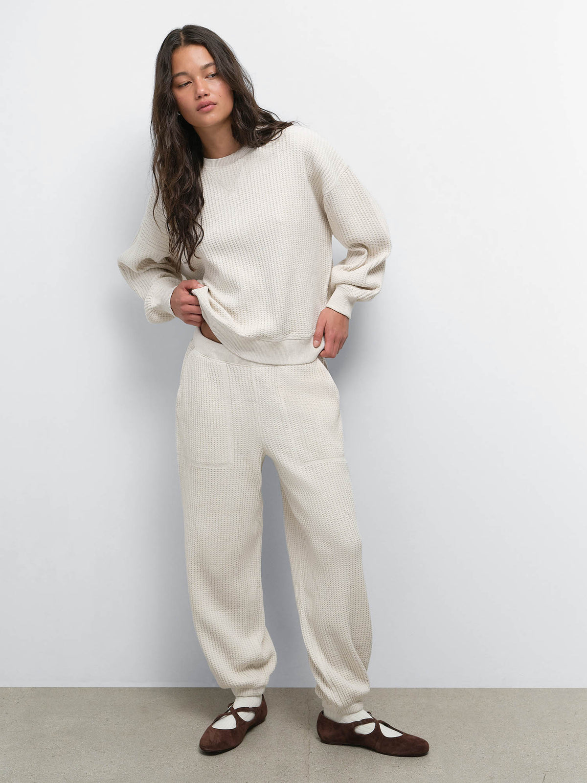 Full-length view of model wearing the Organic Waffle Crewneck Sweatshirt and Sweatpant in Oat