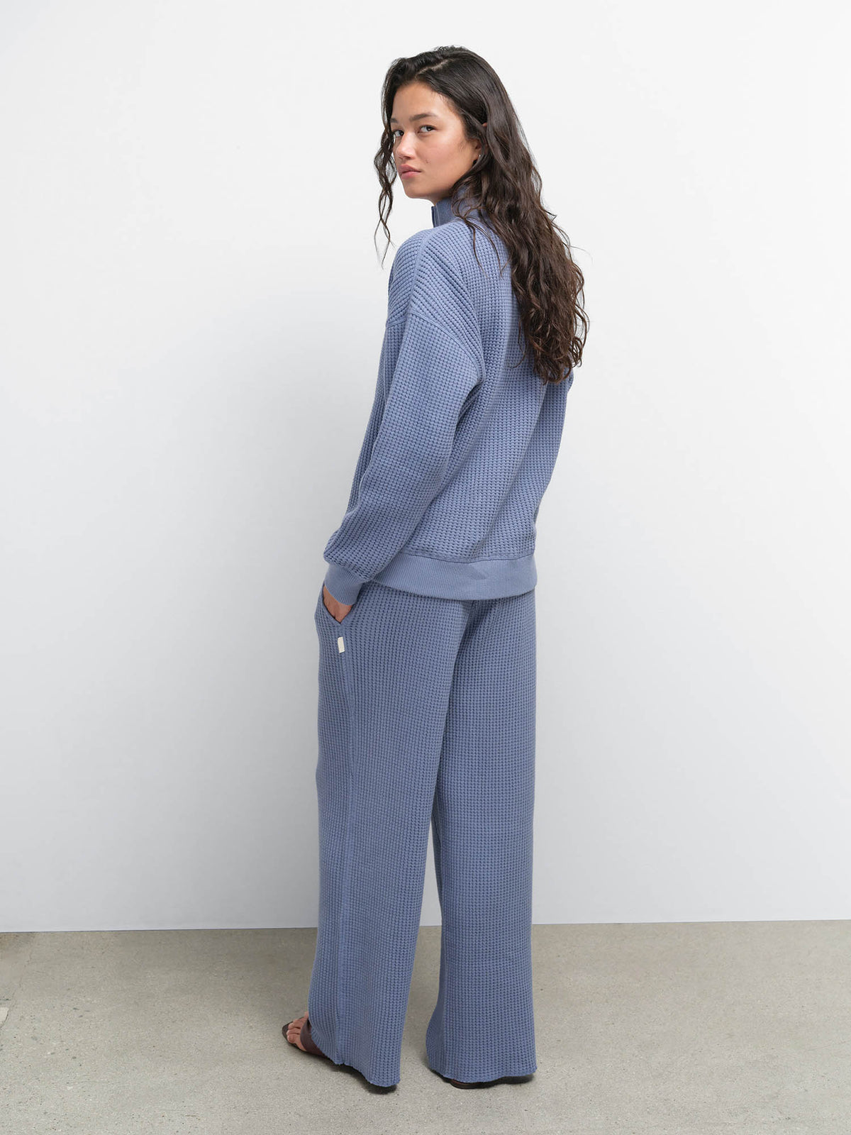 Side view of model with hands in pockets wearing the Organic Waffle Collared Half-Zip and Straight Leg Pant in Bay