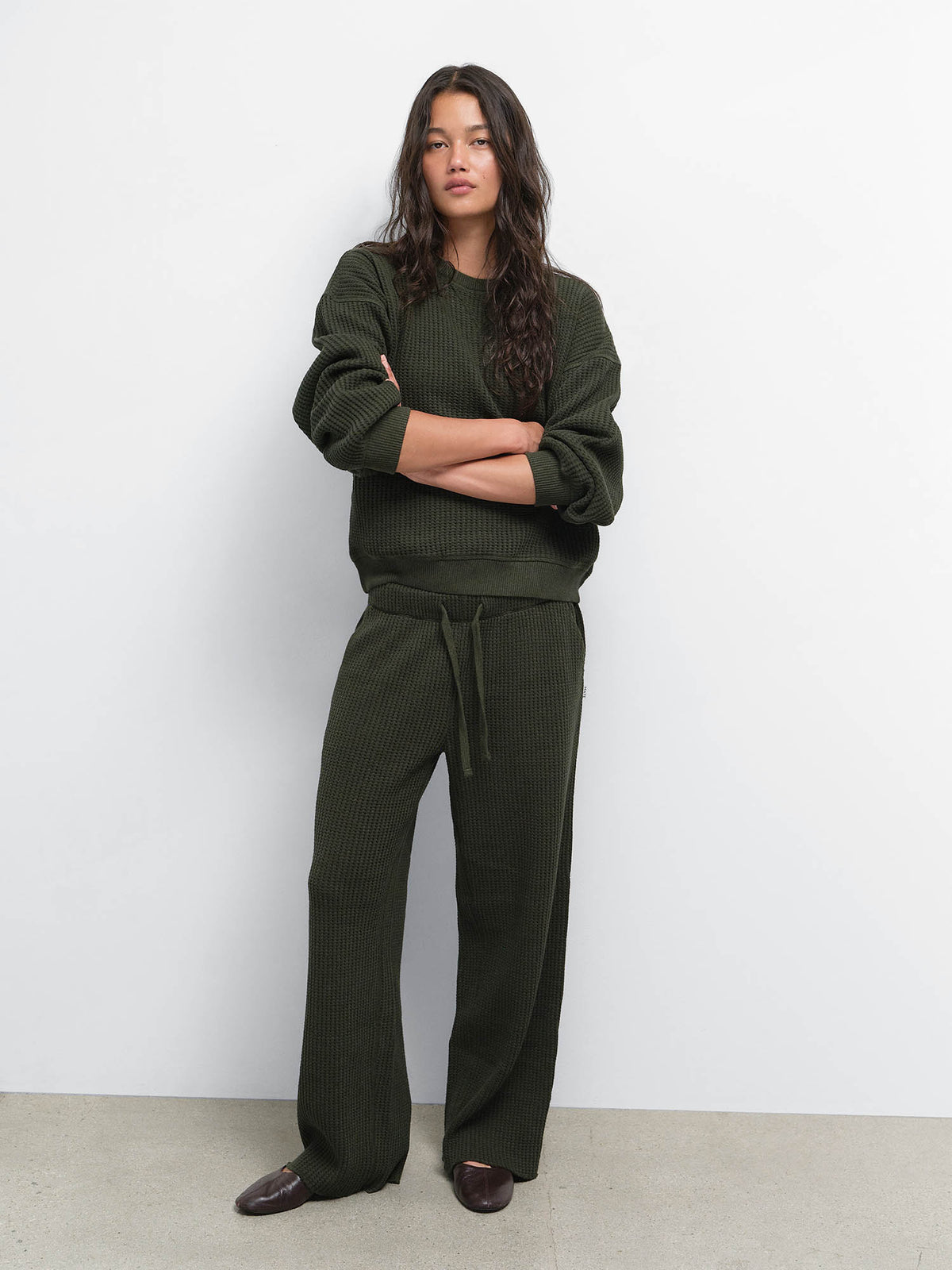 Model standing with arms crossed in the Organic Waffle Crewneck Sweatshirt and Straight Leg Sweatpant in Heather Pine