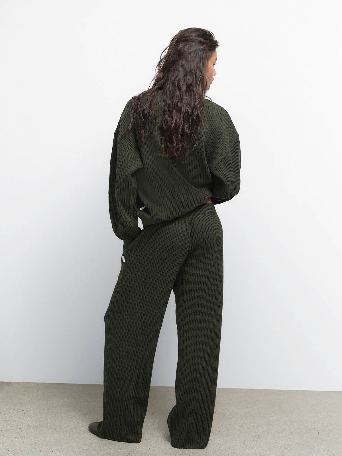 Back view of model wearing the Organic Waffle Crewneck Sweatshirt and Straight Leg Sweatpant in Heather Pine
