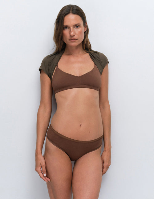 Model wearing a brown bra and underwear set from Mate the Label with an olive green cover-up