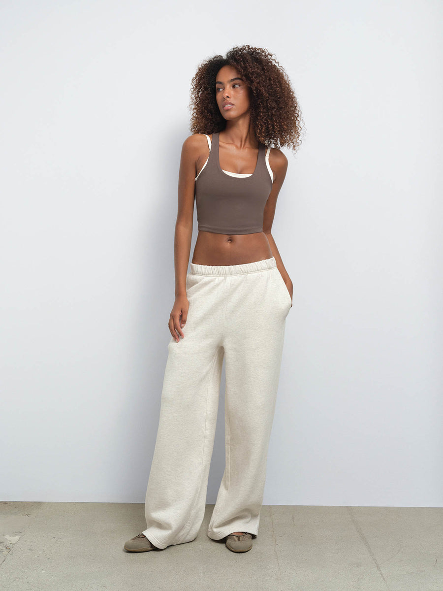 MATE model wearing a taupe ribbed crop top with white trim and heather oat organic fleece relaxed sweatpants against a light background