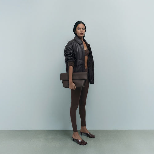 Brown organic sports bra and leggings styled with a black leather jacket and clutch – MATE the Label
