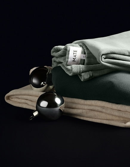 Folded sage and cream loungewear with silver holiday ornaments – MATE the Label